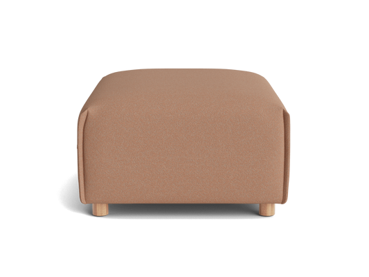 A rectangular ottoman with a soft, peach-colored fabric and light wooden legs, set against a black background.
