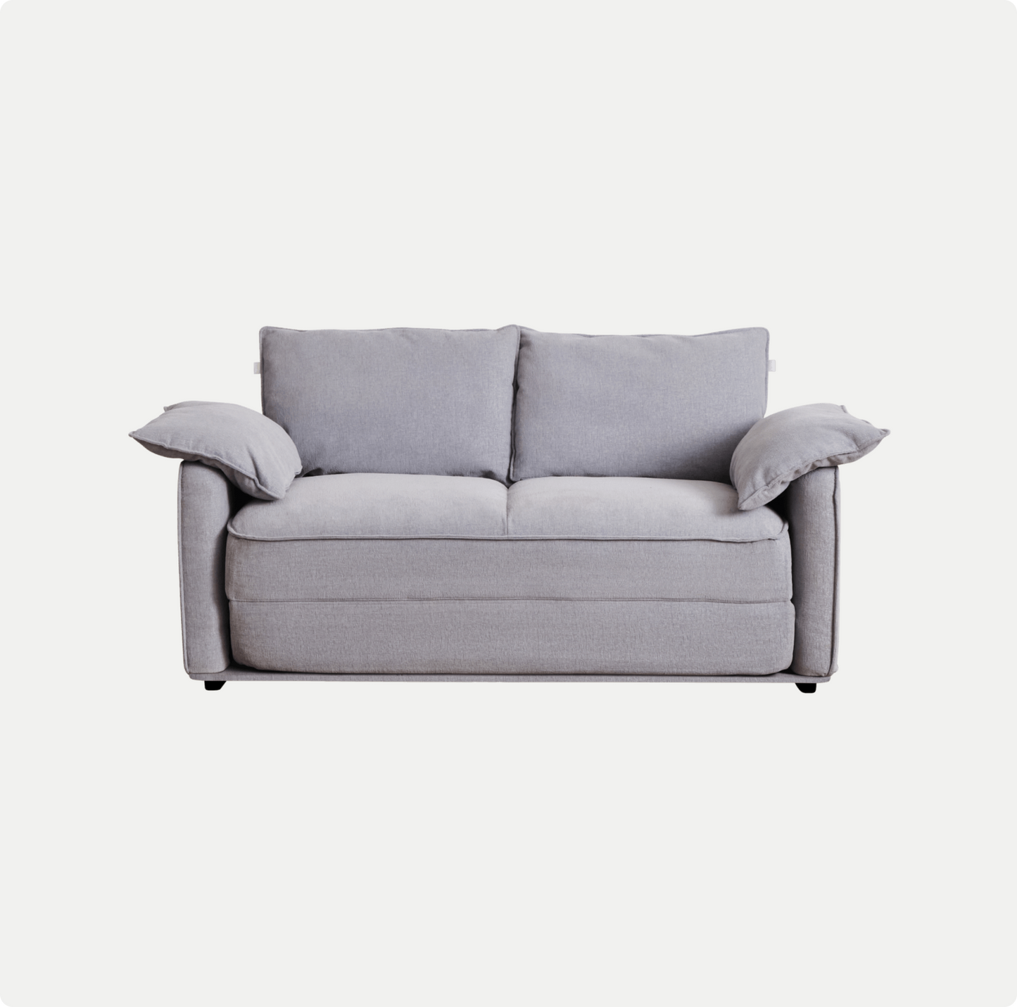 A light grey sofa with two back cushions and two attached armrest pillows, featuring a clean, modern design.
