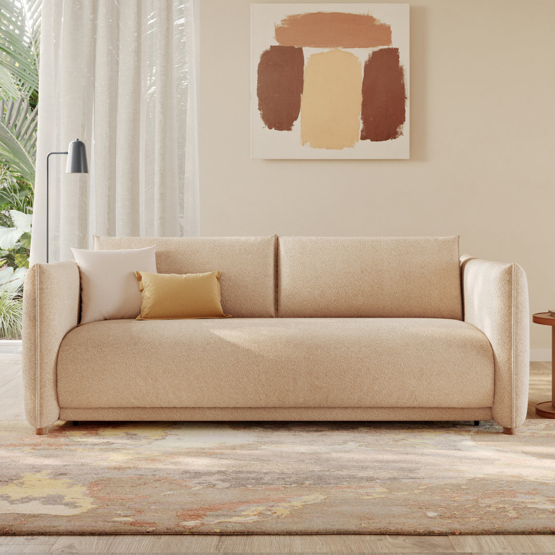 Cozy sunlit living area with cream sofa bed and modern wooden side table.