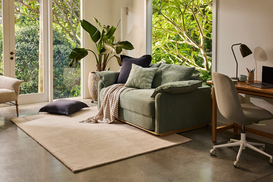 Sofa bed with pillows in cozy room.