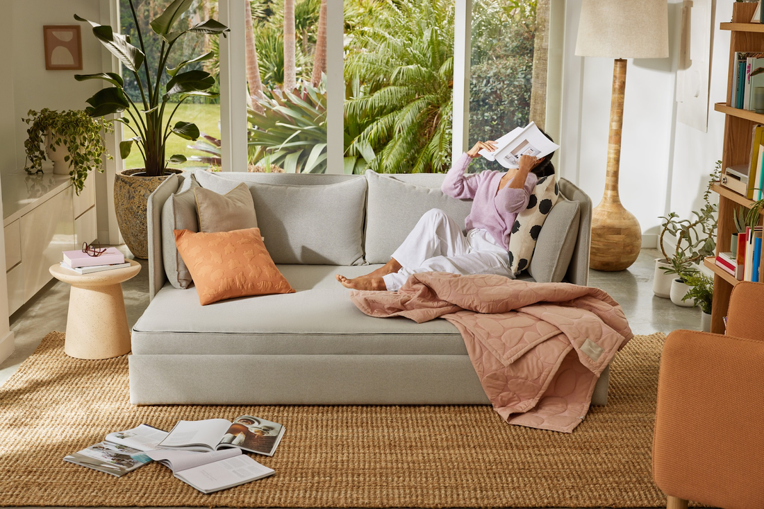 Woman relaxing on sofa bed with pillows. 