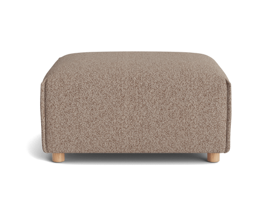 A textured, light brown ottoman with rounded edges and natural wood legs, set against a black background.