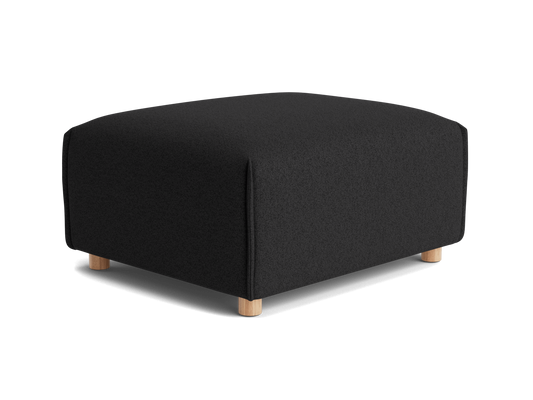 A black ottoman with a textured fabric surface and light wooden legs, featuring a rounded shape and no visible seams.