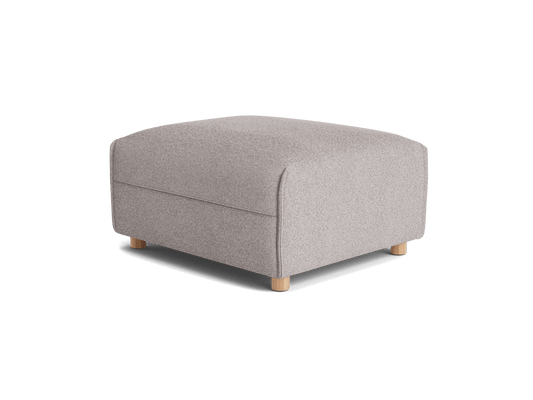 A light grey upholstered ottoman with rounded edges and short wooden legs, on a transparent background.