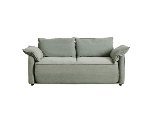 A soft, light sage green sofa with two large back cushions and two side pillows, set against a black background.