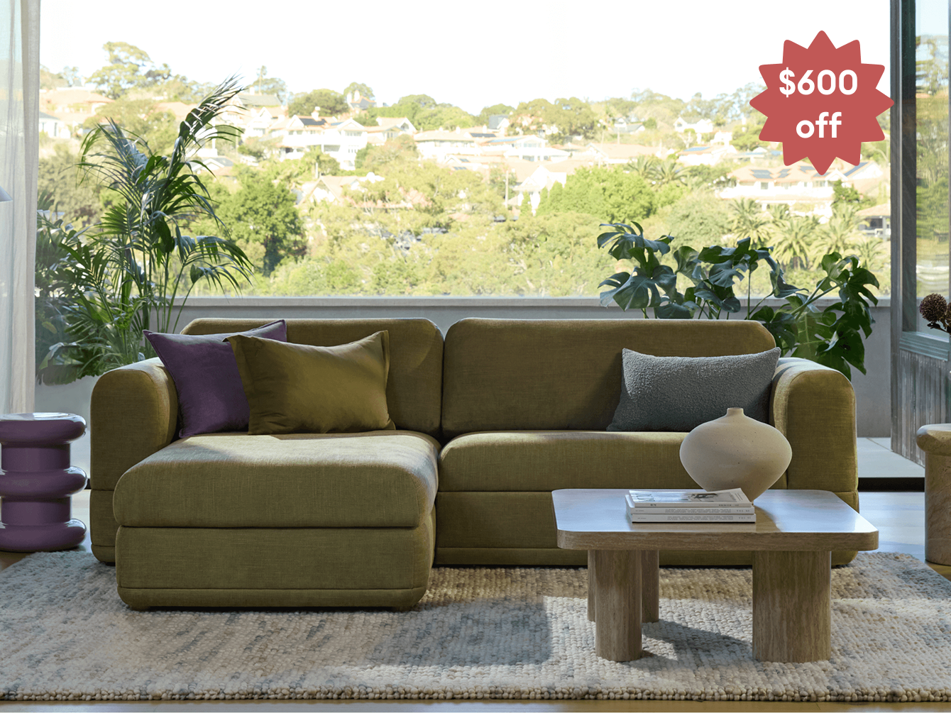 Olive-green Koala sofa with chaise in sunny living room with red starburst badge reading "$600 off"