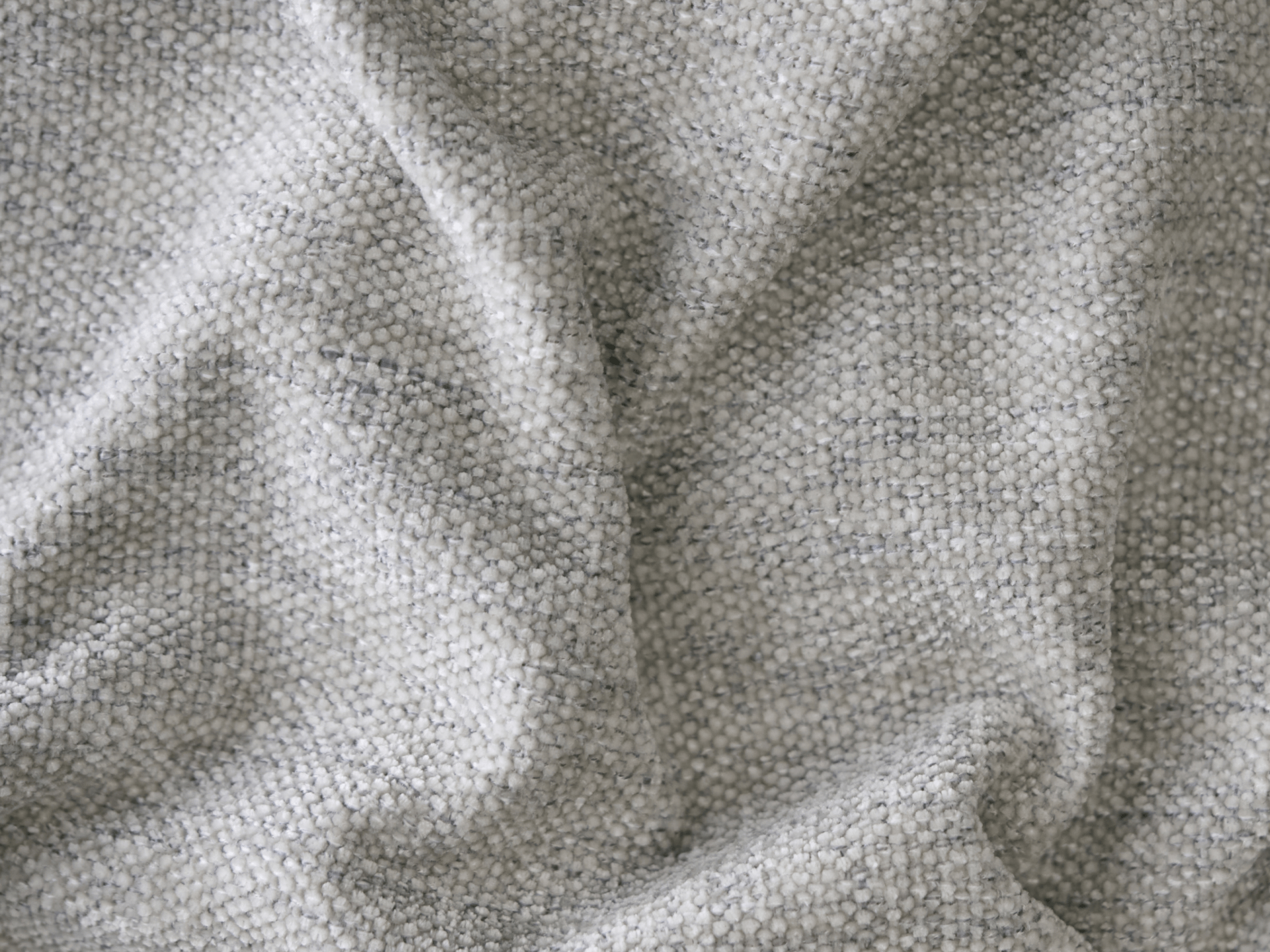Textured boucle fabric in soft grey tones, featuring a modern, cosy finish. Ideal for luxurious sofas or armchairs in contemporary living spaces.