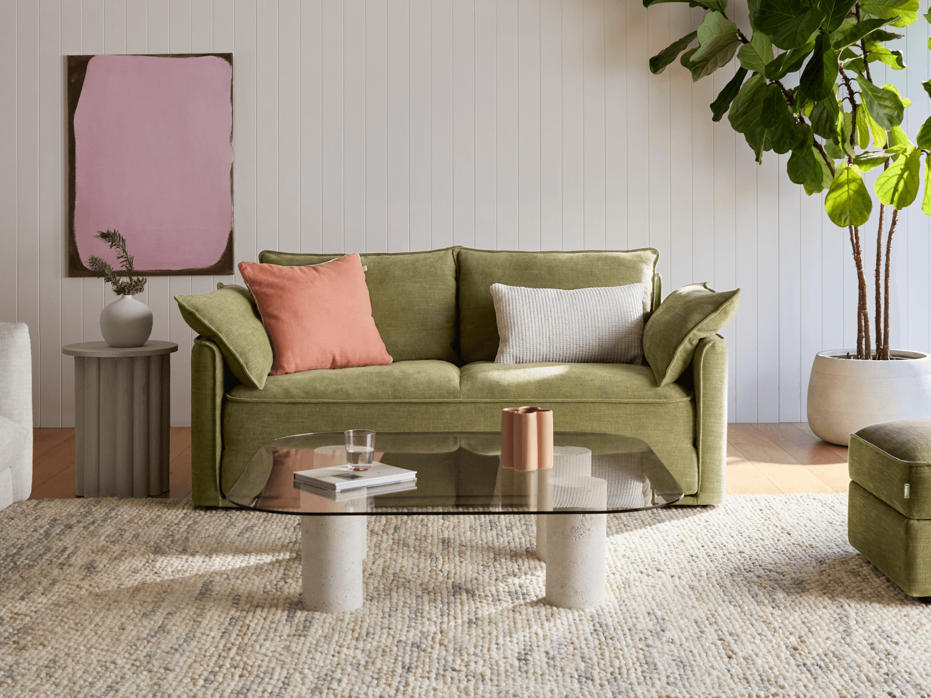 Comfortable Koala sofa bed in olive green fabric, styled in a modern living room with a glass coffee table