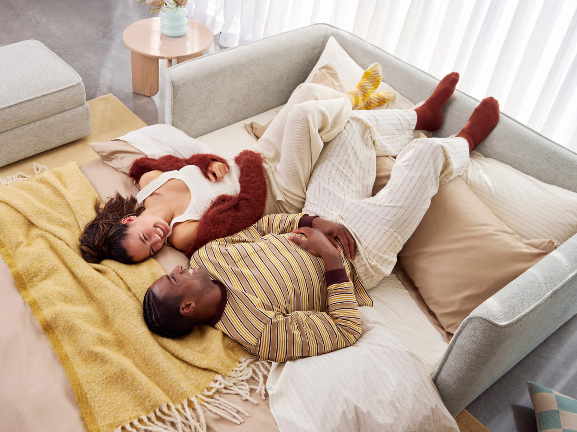 Koala Cushy Sofa Bed in sandstone with people lounging in bed mode