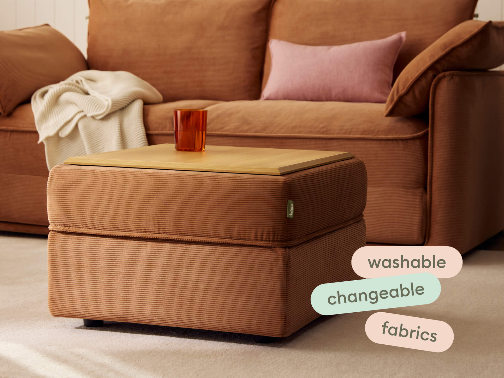 Luxury ottoman in rich terracotta corduroy with a removable wooden tray top, set in a cosy living room with a matching sofa, featuring washable fabrics.