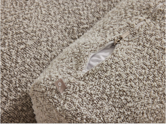 Beige boucle fabric sofa with textured upholstery, showcasing a discreet zip detail. The luxurious finish adds elegance to any modern living space.