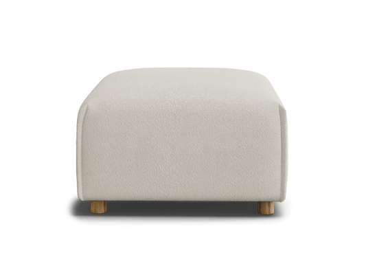 A light beige ottoman with rounded edges sits on small wooden legs against a black background.