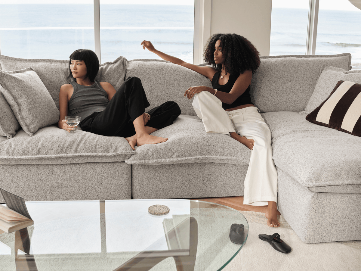 Koala Tamarama 3-section chaise modular sofa in Aussie Latte, with two models reclining and terracotta cushion