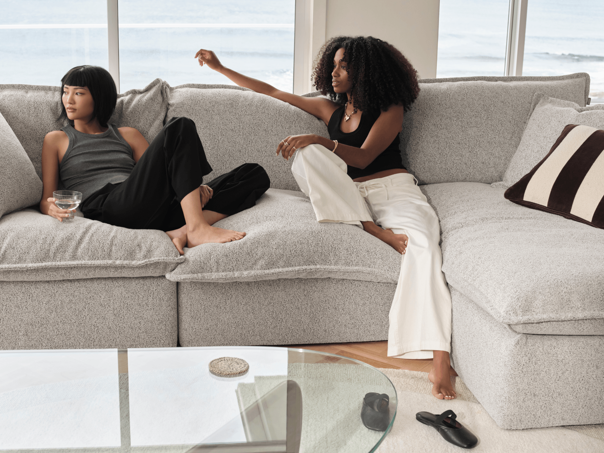 Koala Tamarama 4-section chaise modular sofa in Aussie Latte, with two models reclining and terracotta cushion