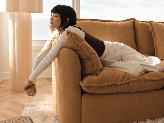 Koala Tamarama 2-section chaise modular sofa in Bronzed Aussie, with two models reclining and terracotta cushion