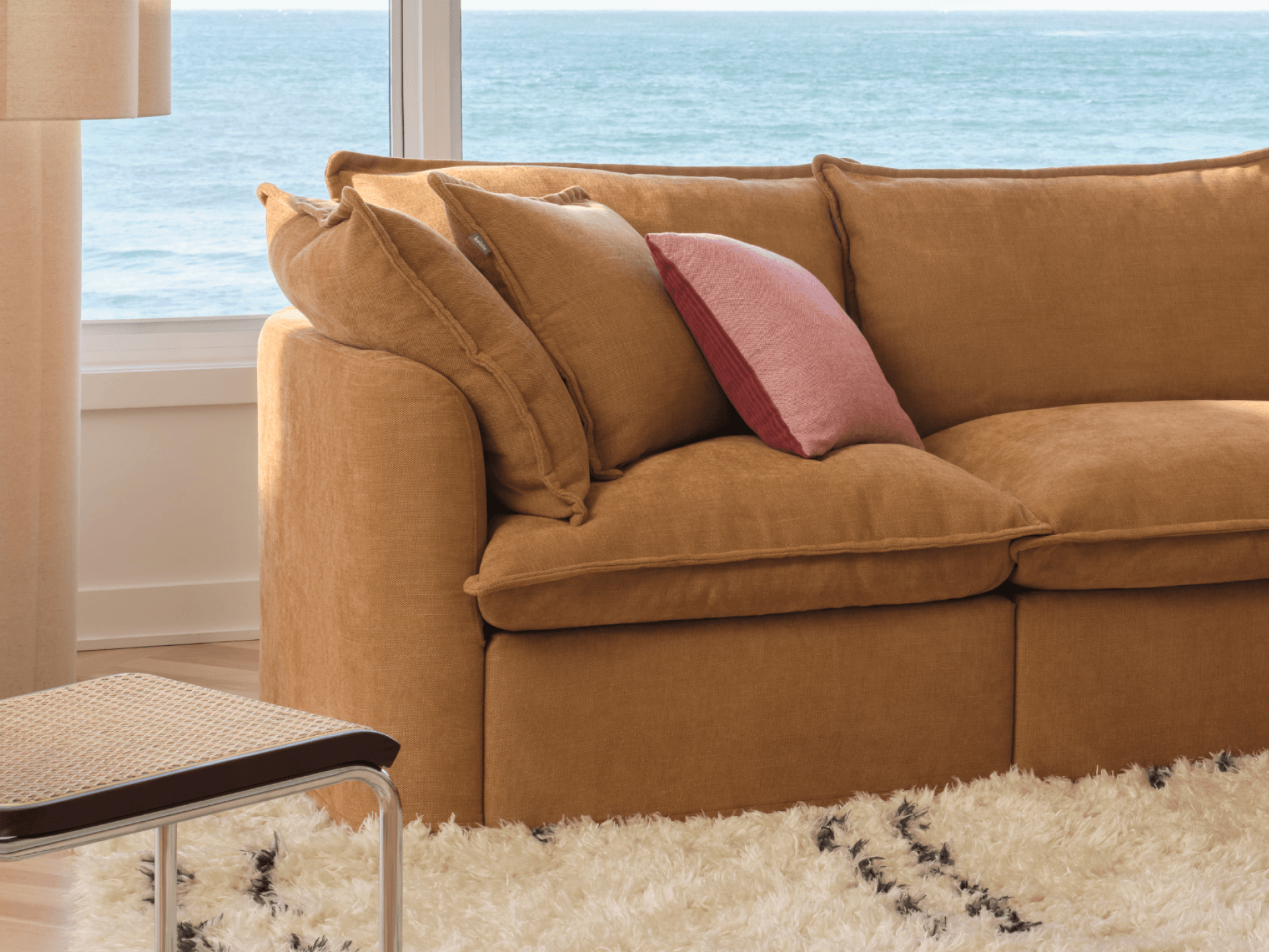 Koala Tamarama 2-section modular sofa in Bronzed Aussie, in coastal living room with ocean view and glass table