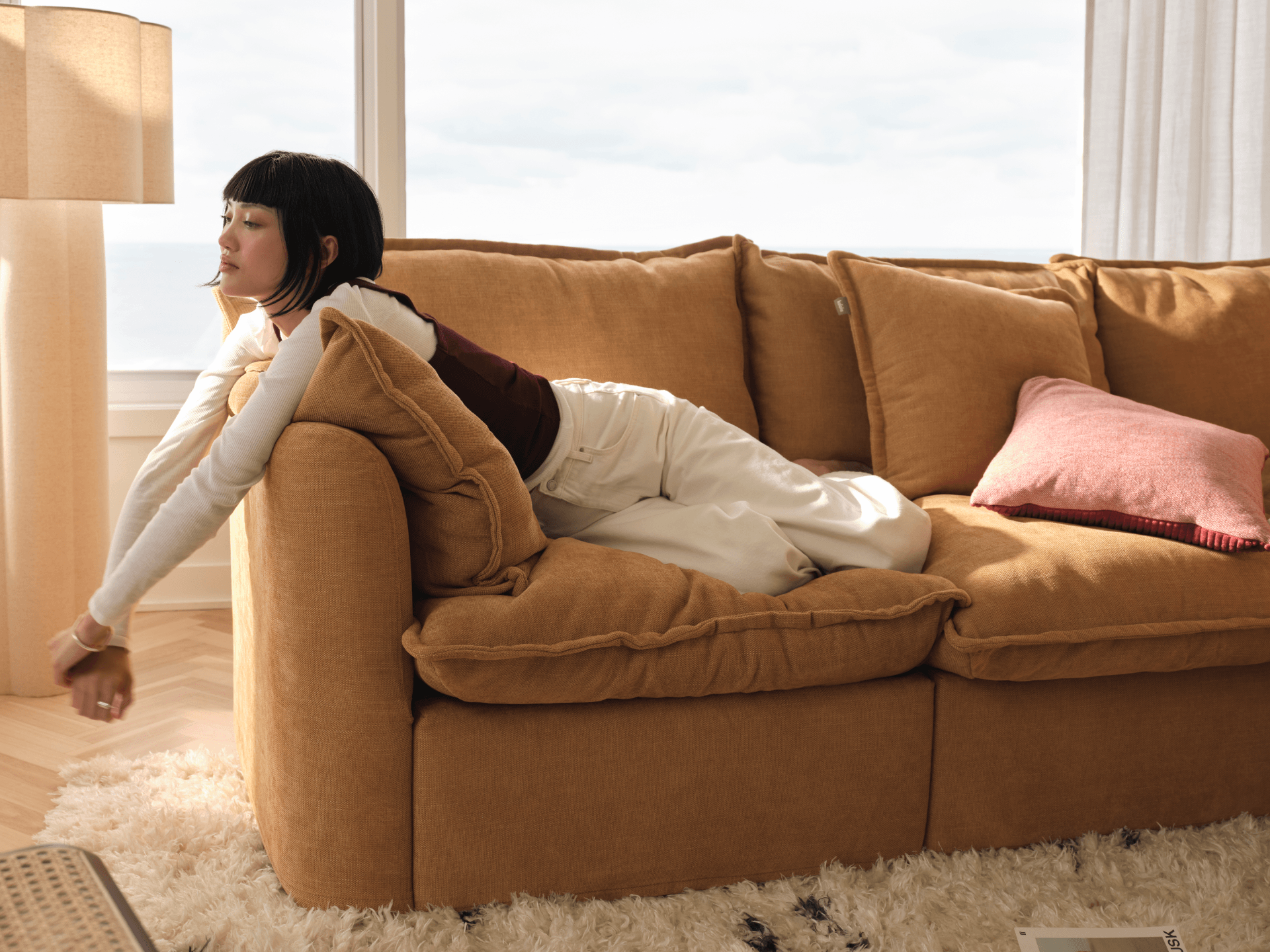 Koala Tamarama 3-section chaise modular sofa in Bronzed Aussie, with two models reclining and terracotta cushion