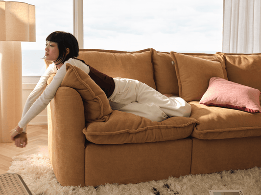 Koala Tamarama 3-section chaise modular sofa in Bronzed Aussie, with two models reclining and terracotta cushion