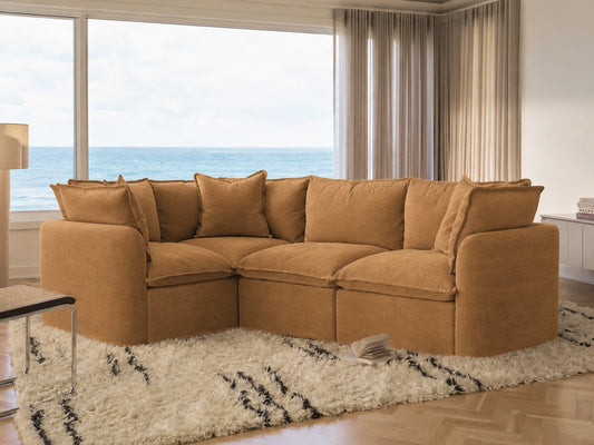 Brown sectional sofa in a living room with large windows overlooking the ocean.