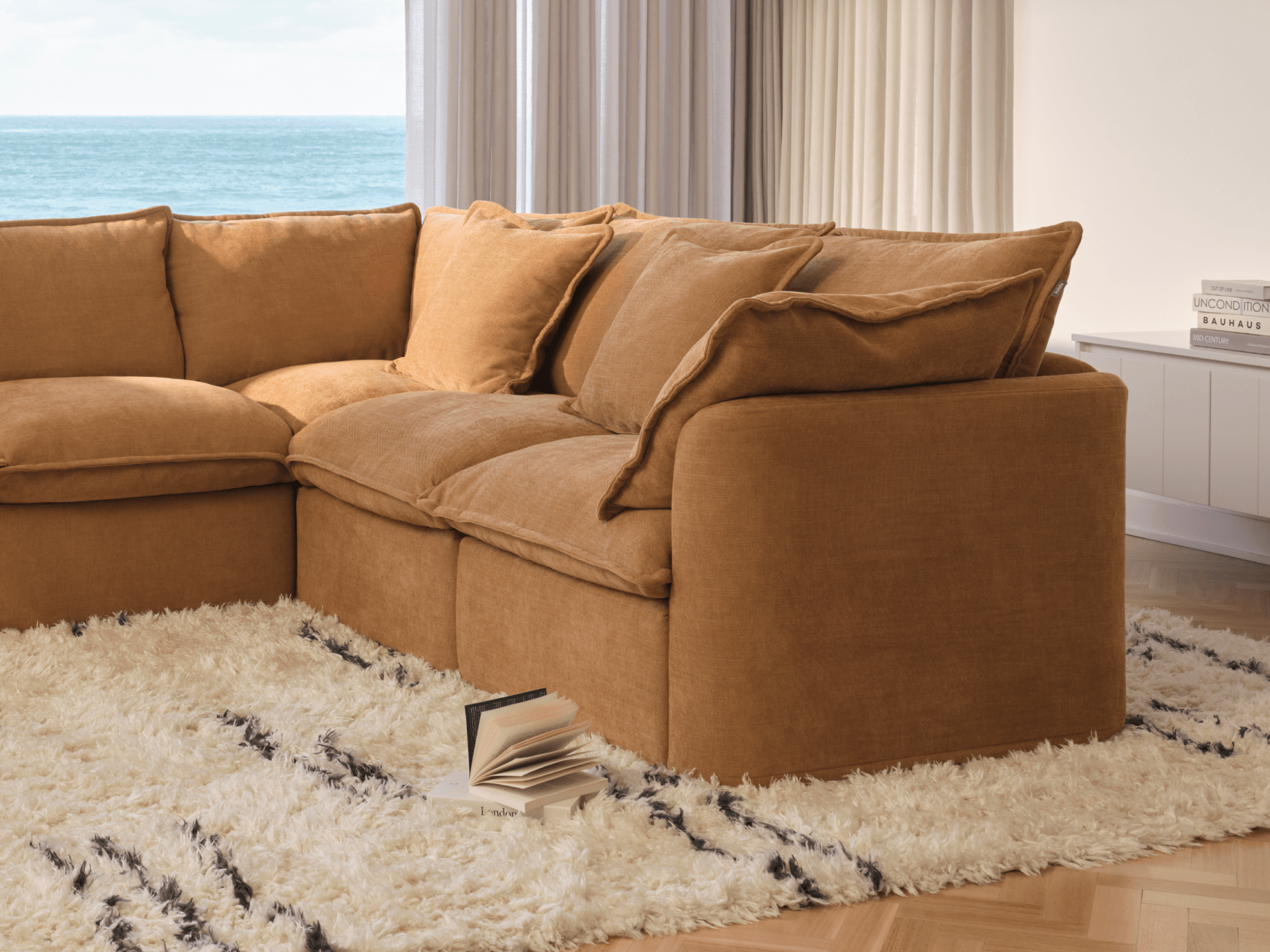 Koala Tamarama 4-section L-shape sectional in Bronzed Aussie, with terracotta velvet cushion and city view