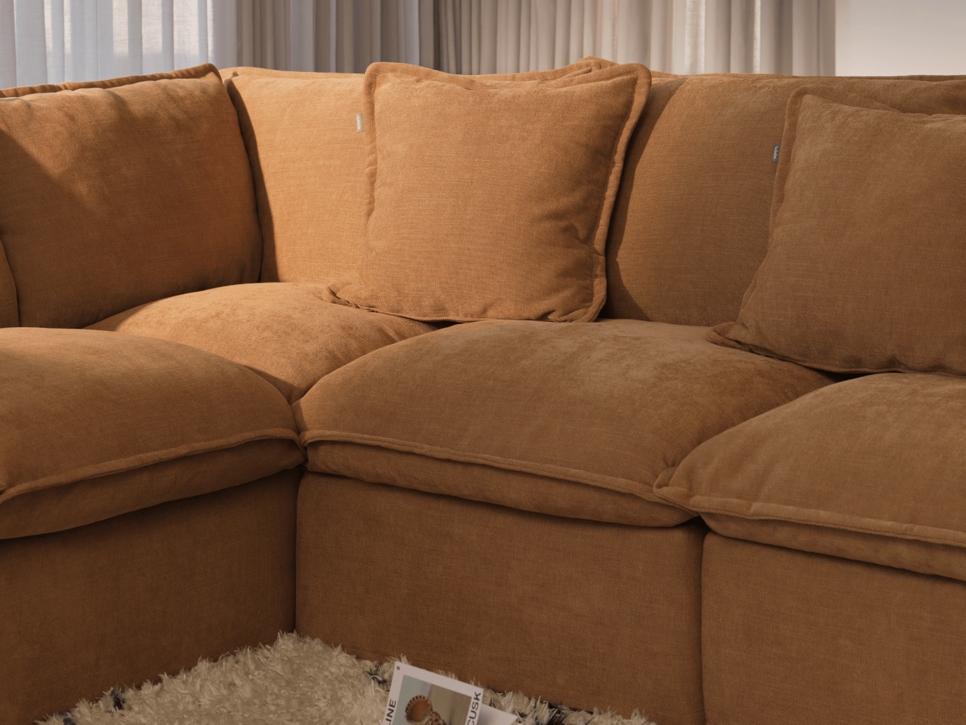 Koala Tamarama 4-section L-shape sectional in Bronzed Aussie, linen scatter cushions with sunlit art books