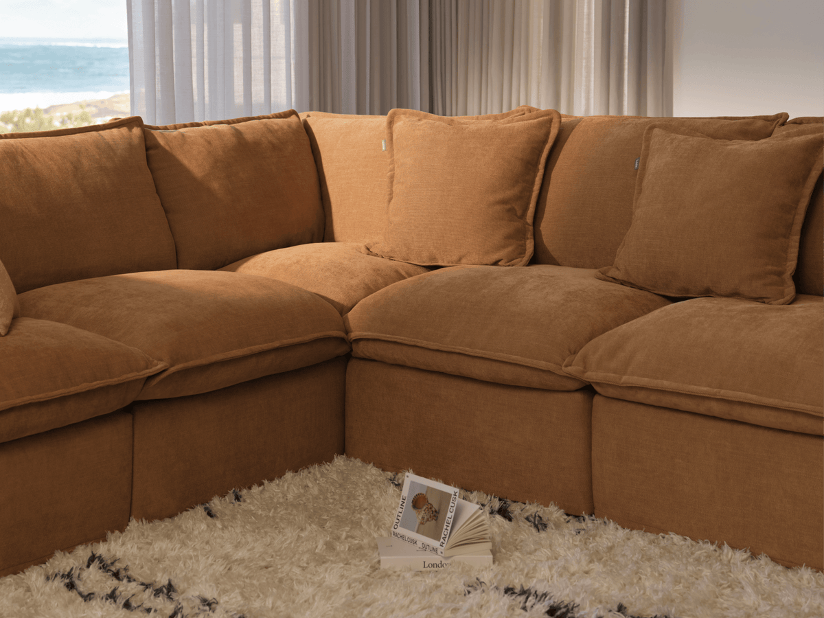 Koala Tamarama 5-section L-shape sectional in Bronzed Aussie, linen scatter cushions with sunlit art books