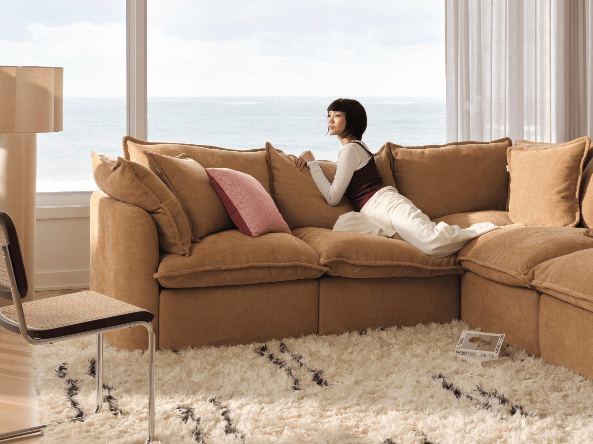 Koala Tamarama 6-section L-shape sectional in Bronzed Aussie, with terracotta velvet cushion and city view