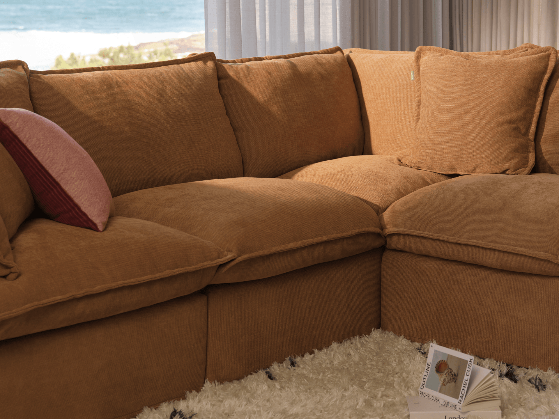 Koala Tamarama 6-section U-shape sectional in Bronzed Aussie, with model, brown knit cushion and bookshelves backdrop