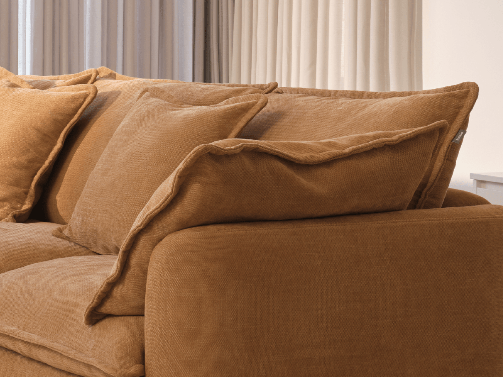 Koala Tamarama 6-section U-shape sectional in Bronzed Aussie, linen scatter cushions with sunlit art books
