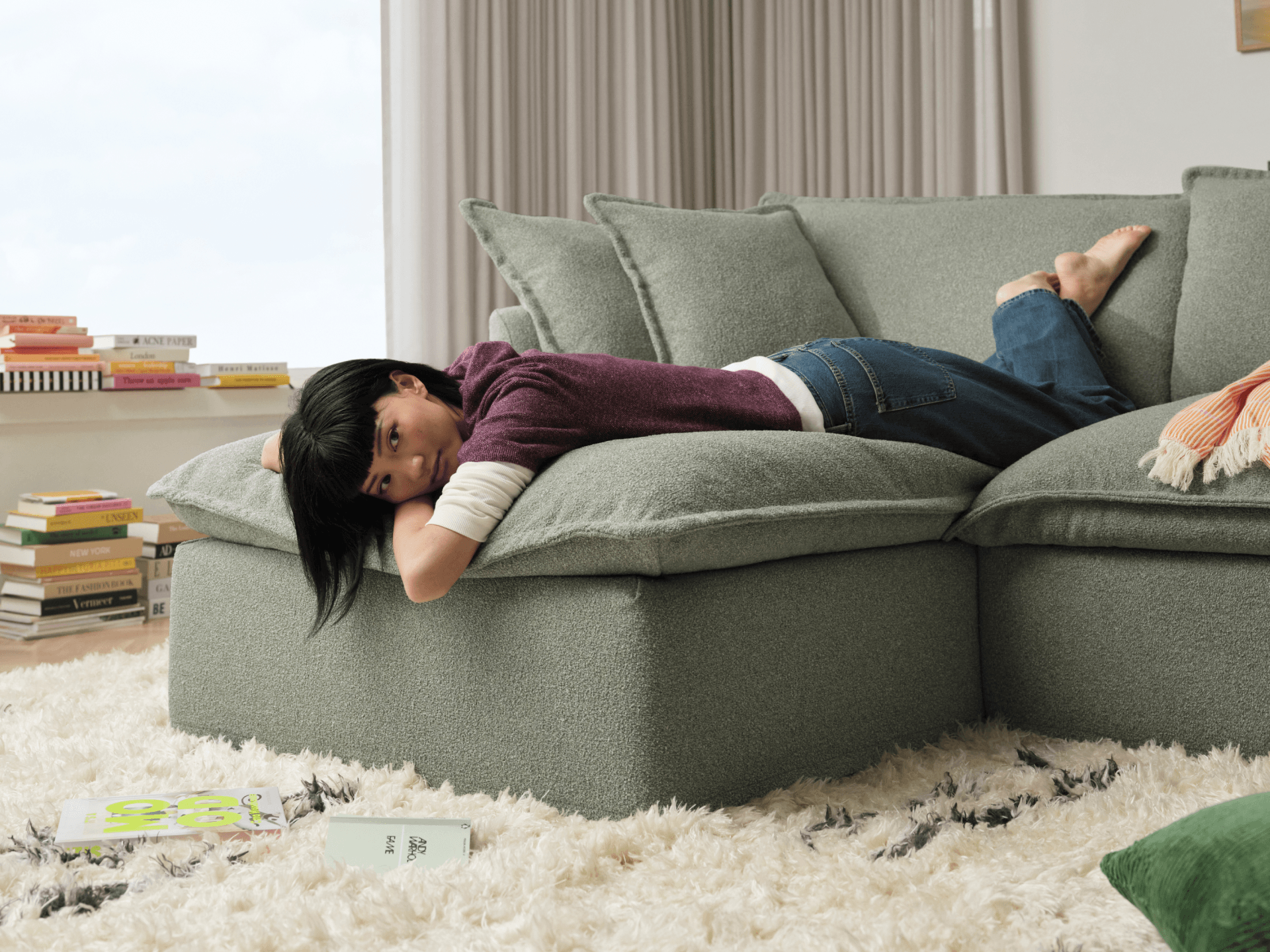 Koala Tamarama 2-section chaise modular sofa in Frosty Grass, with two models reclining and terracotta cushion