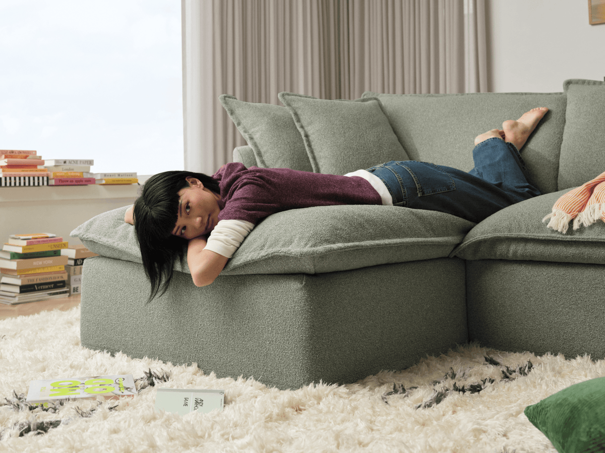 Koala Tamarama 4-section chaise modular sofa in Frosty Grass, with two models reclining and terracotta cushion