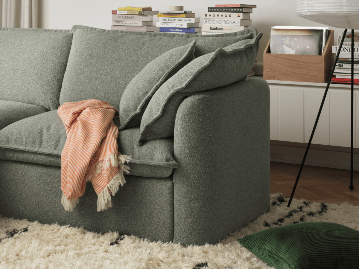 Koala Tamarama 4-section L-shape sectional in Frosty Grass, with terracotta velvet cushion and city view