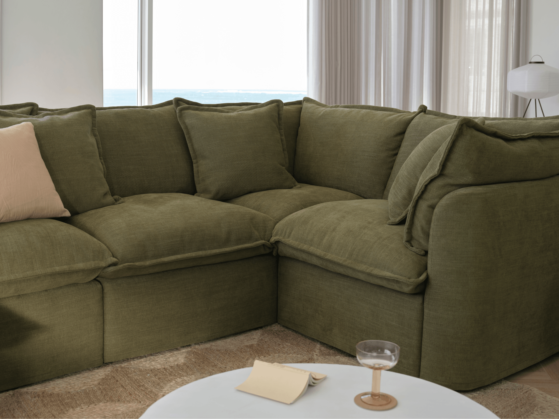Koala Tamarama 4-section L-shape sectional in Forest Walk, with terracotta velvet cushion and city view