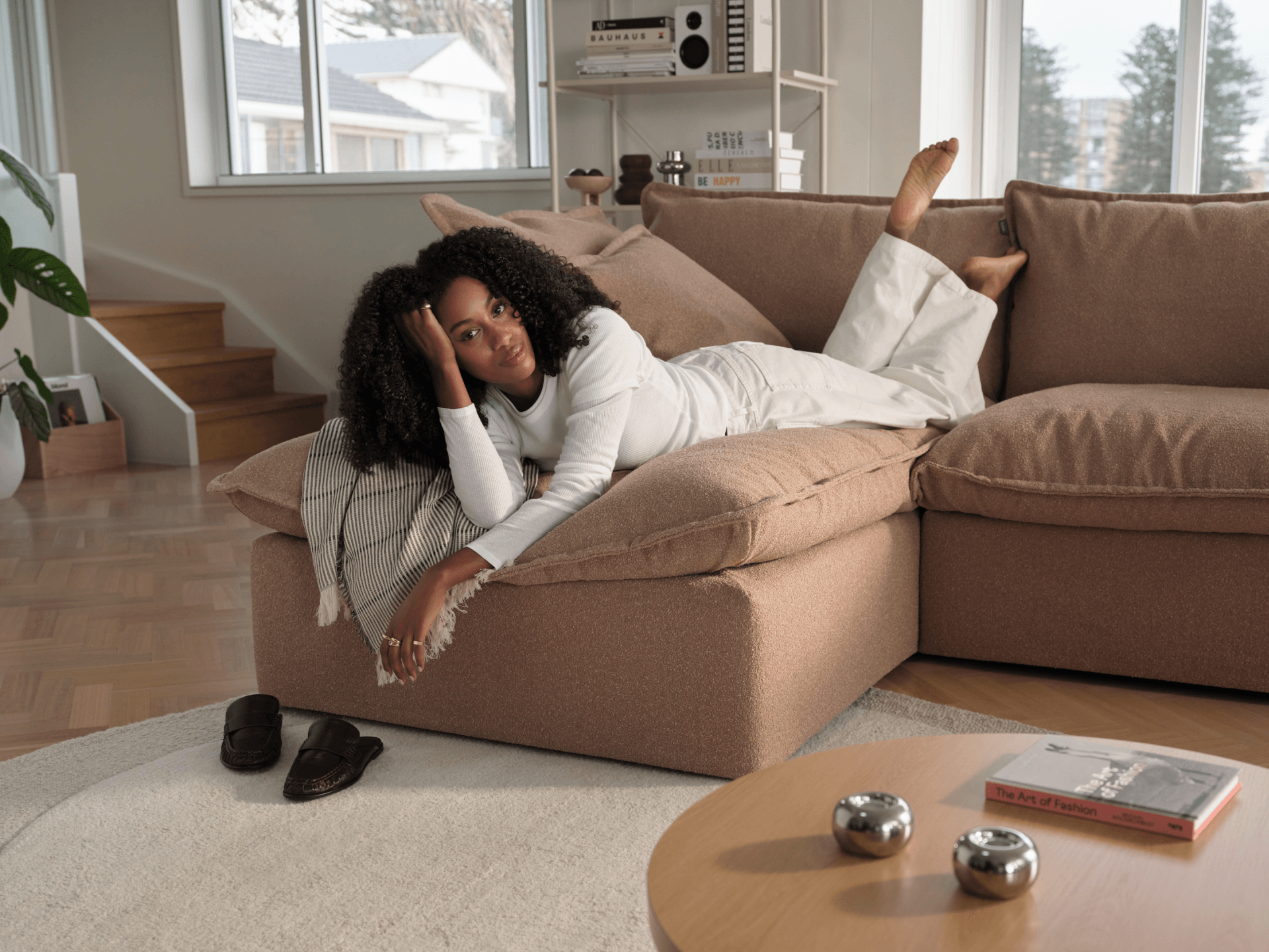 Koala Tamarama 4-section chaise modular sofa in Pebble Beach, with two models reclining and terracotta cushion