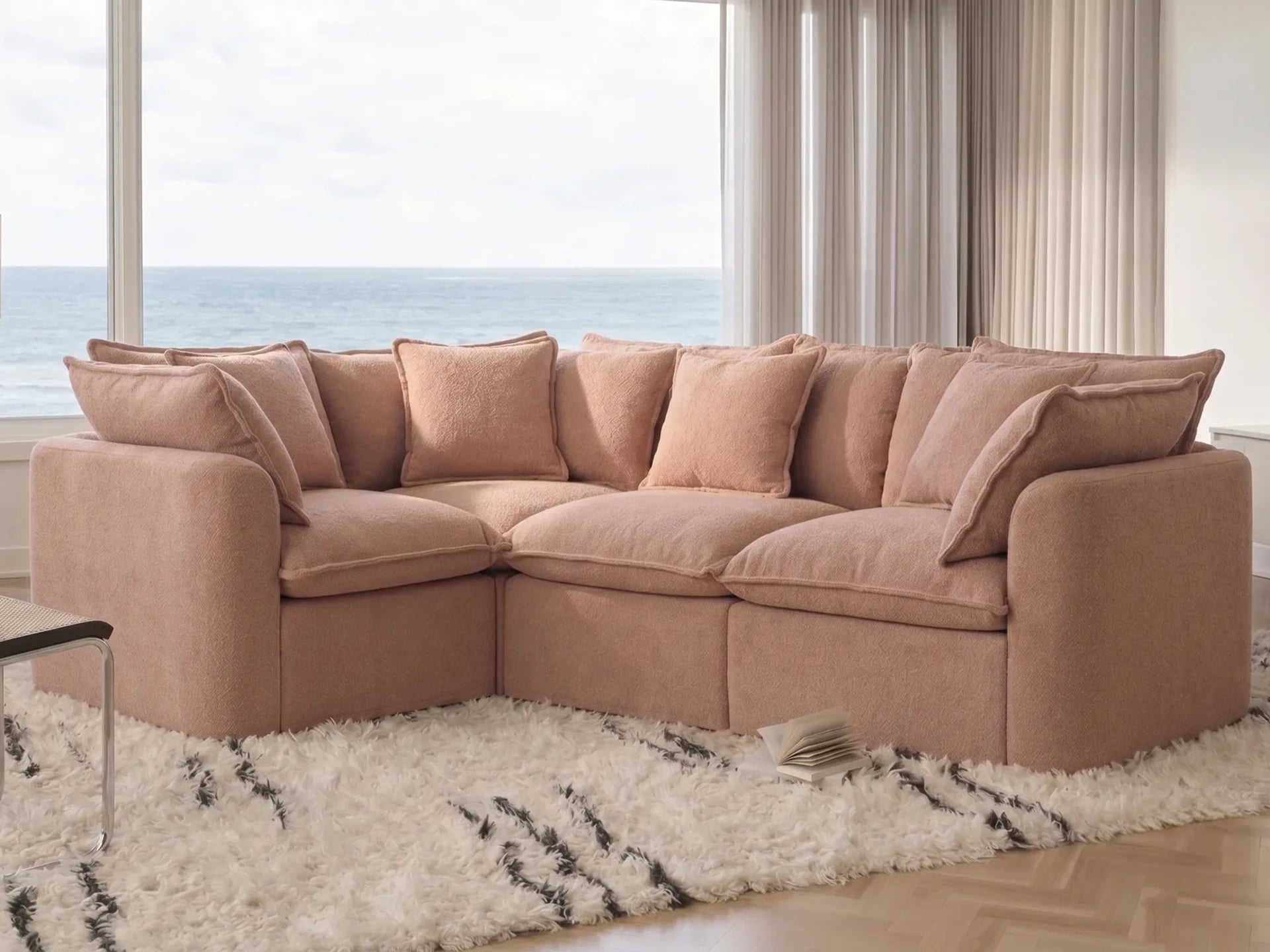 sectional sofa in a room with large windows and a view of water.