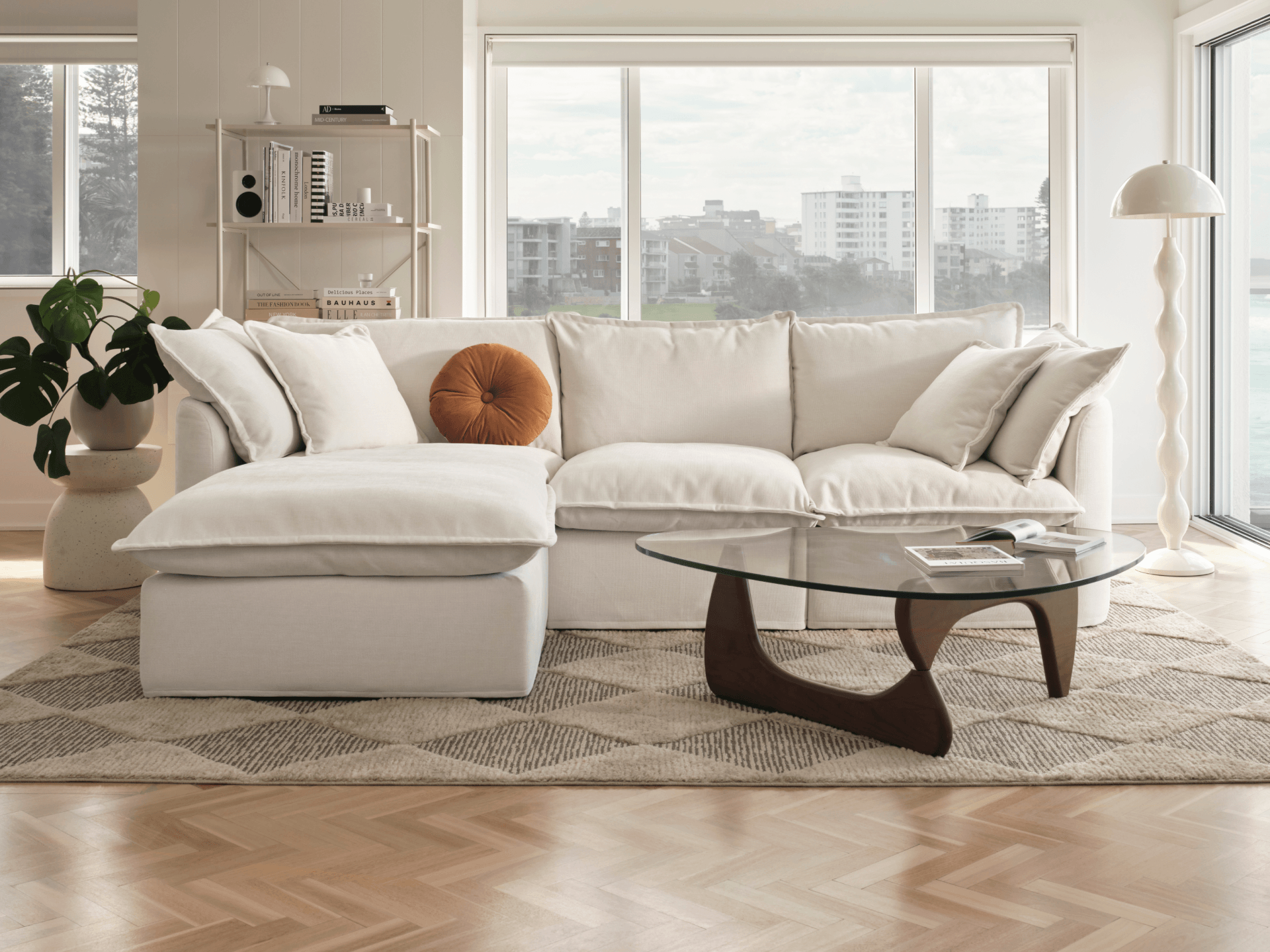 Koala Tamarama 3-section chaise modular sofa in Winter Cream, with monstera plant and Noguchi glass table