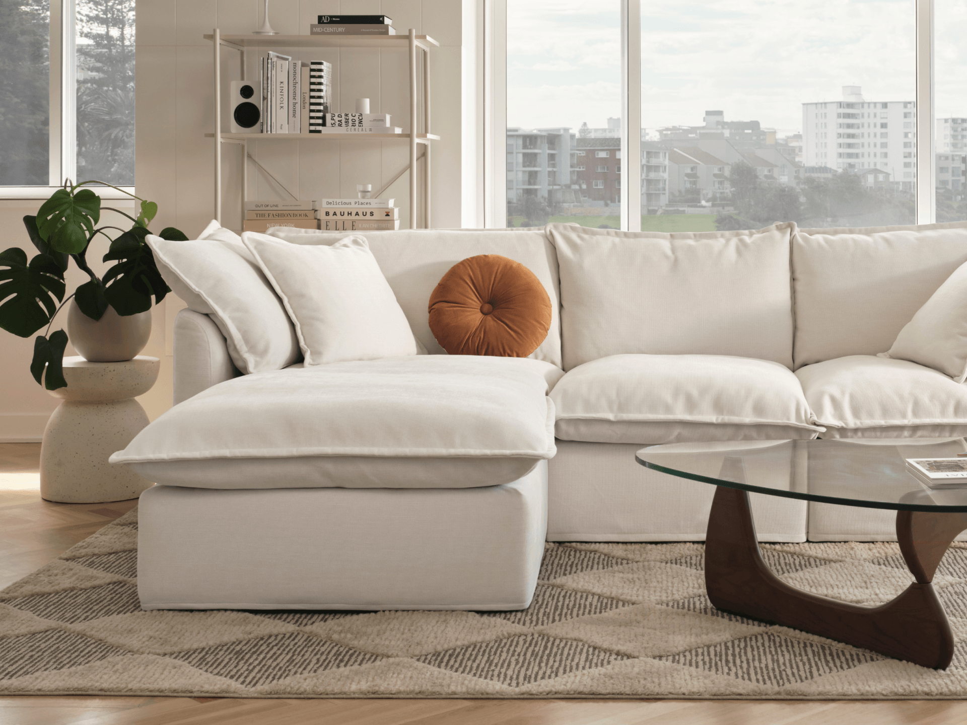 Koala Tamarama 4-section chaise modular sofa in Winter Cream, with monstera plant and Noguchi glass table
