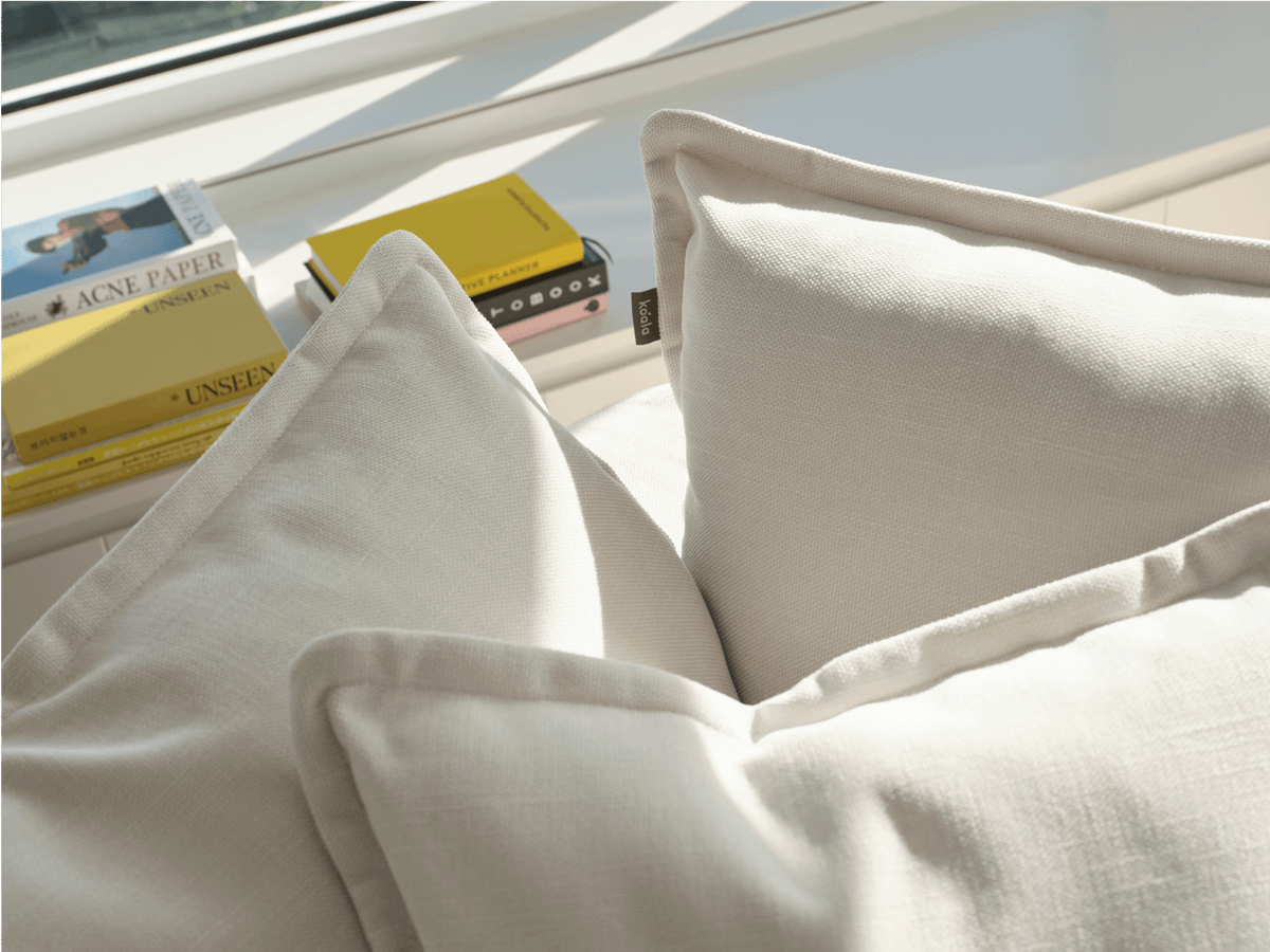 Koala Tamarama 6-section U-shape sectional in Winter Cream, linen scatter cushions with sunlit art books