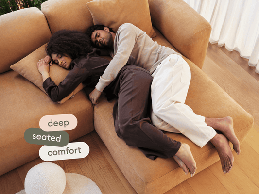 Luxurious tan sectional sofa in soft fabric, featuring deep seating and plush cushions. Set on polished wooden flooring in a chic, modern living space.