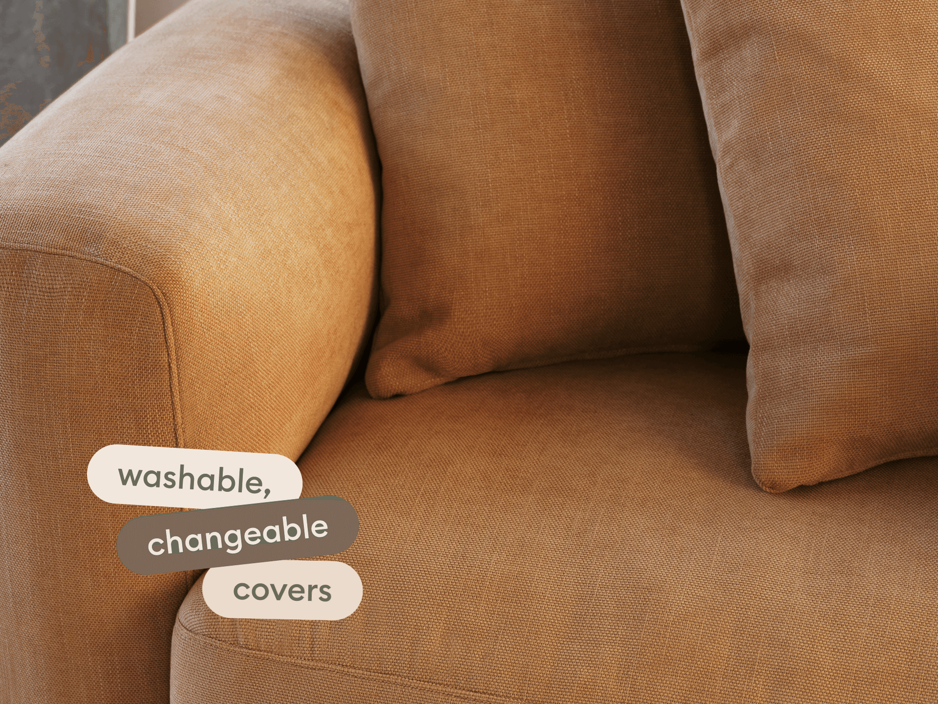 Modern sofa with plush, washable, changeable fabric in warm tan. Features rounded edges and deep cushioning. Perfect for a sophisticated living space.