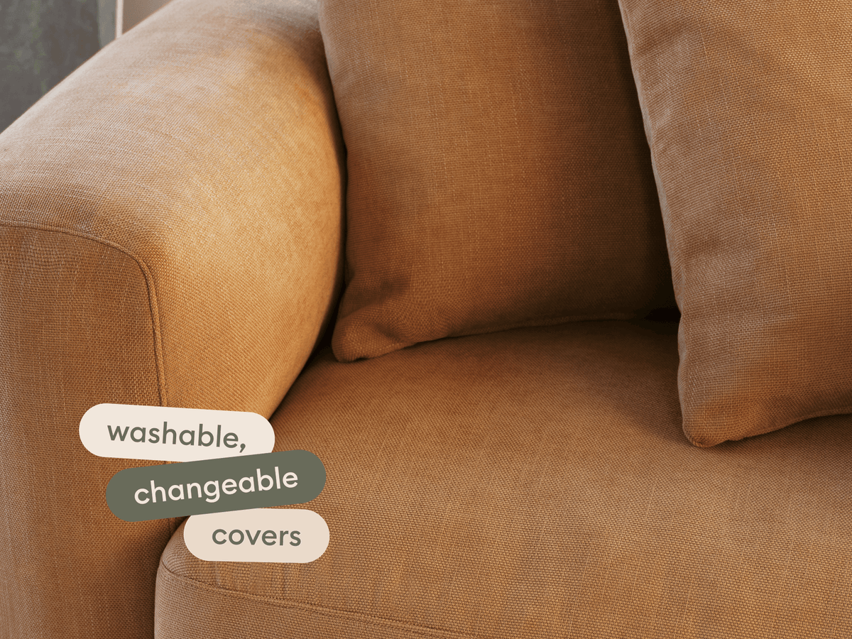 Luxurious brown fabric sofa with washable, changeable covers, featuring plush cushions and a modern design. Perfect for an elegant living room setting.