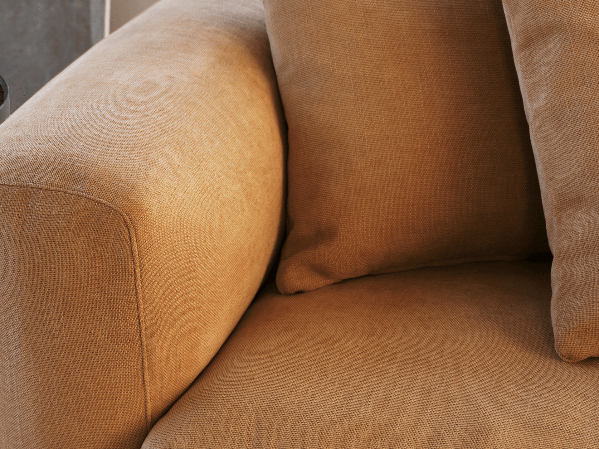 Luxurious beige linen armchair with plush cushions. Features rounded armrests and a textured finish, nestled in a contemporary living room setting.