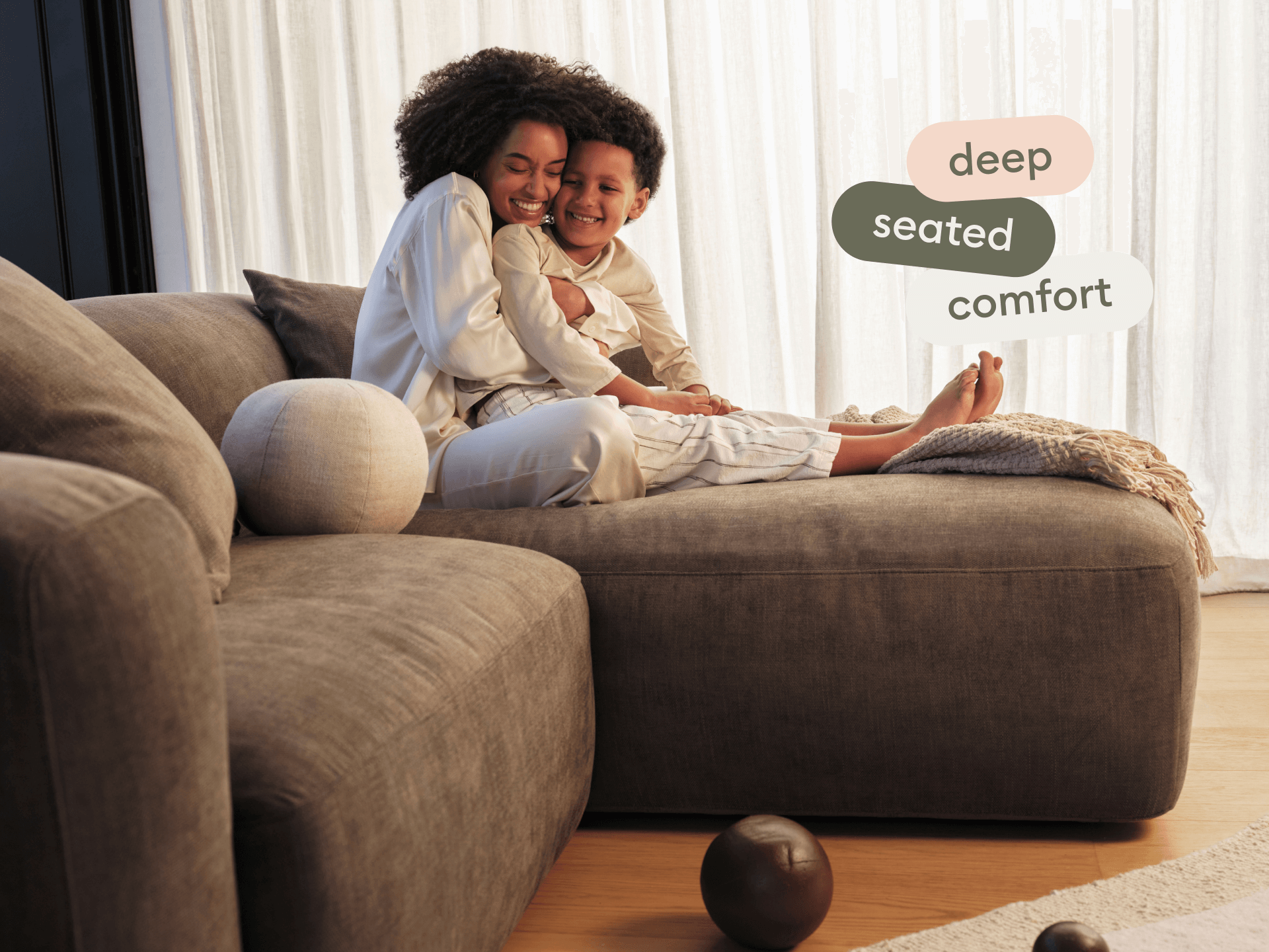 Luxurious grey sectional sofa in plush fabric, featuring deep seating and sleek lines, set in a modern living room with light wooden floors.