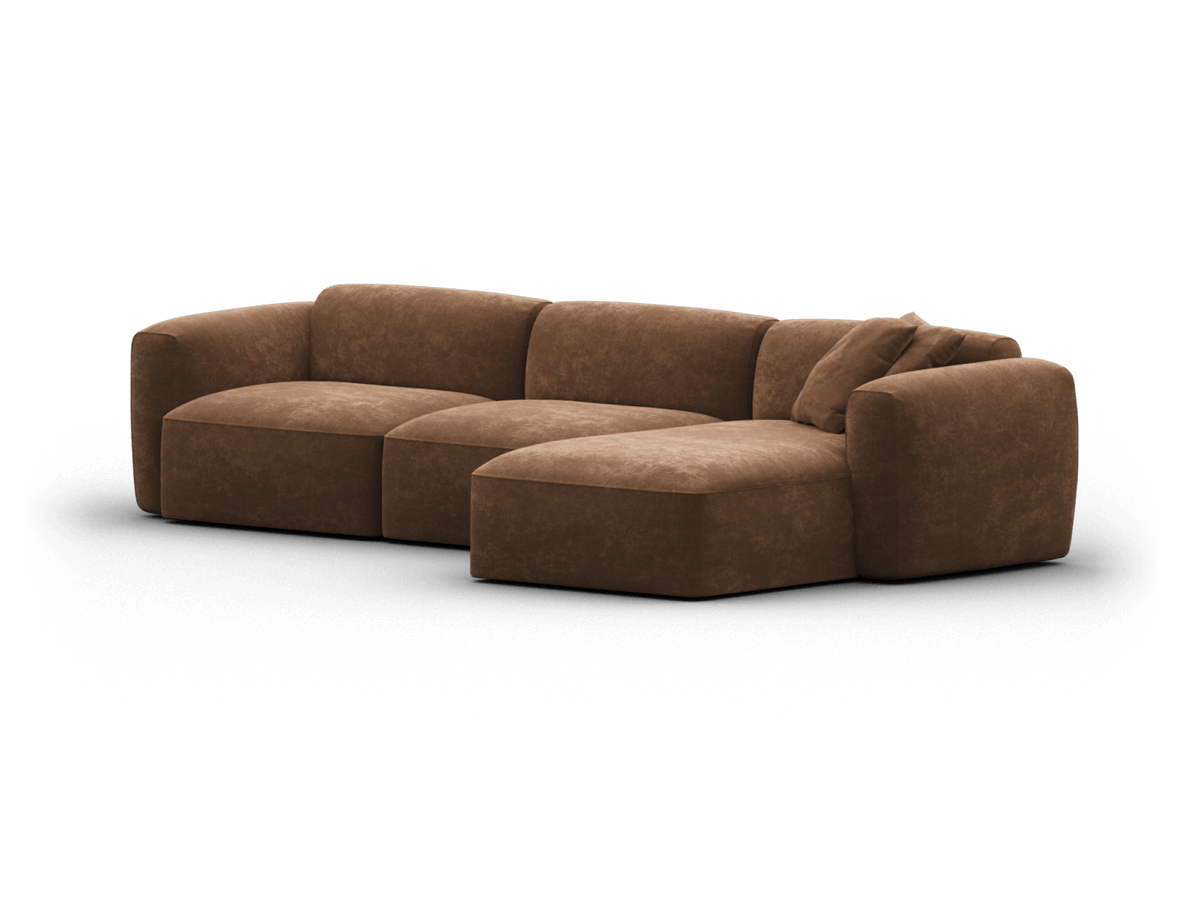 Brown suede modular sofa with plush cushions, featuring an extended chaise. Soft curves and minimalist design ideal for premium contemporary living spaces.
