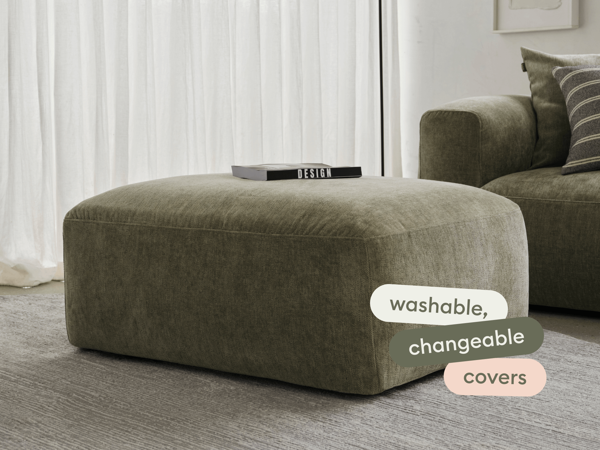 Luxurious olive ottoman with washable, changeable covers. Upholstered in plush fabric, it complements a modern living room with its sleek, minimalist design.