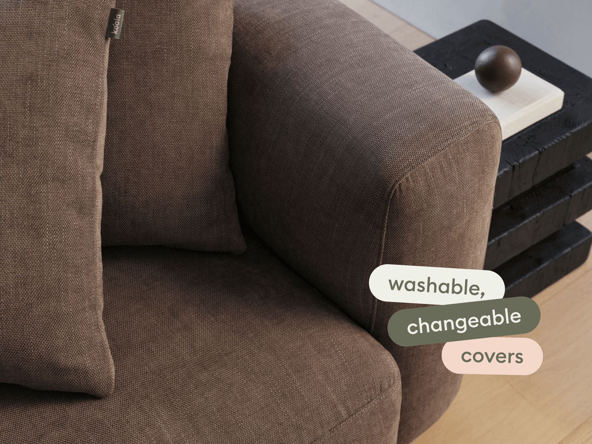 Modern sofa with rich brown, textured fabric and washable, changeable covers. Features plush cushions, set in a stylish living space with wooden floors.