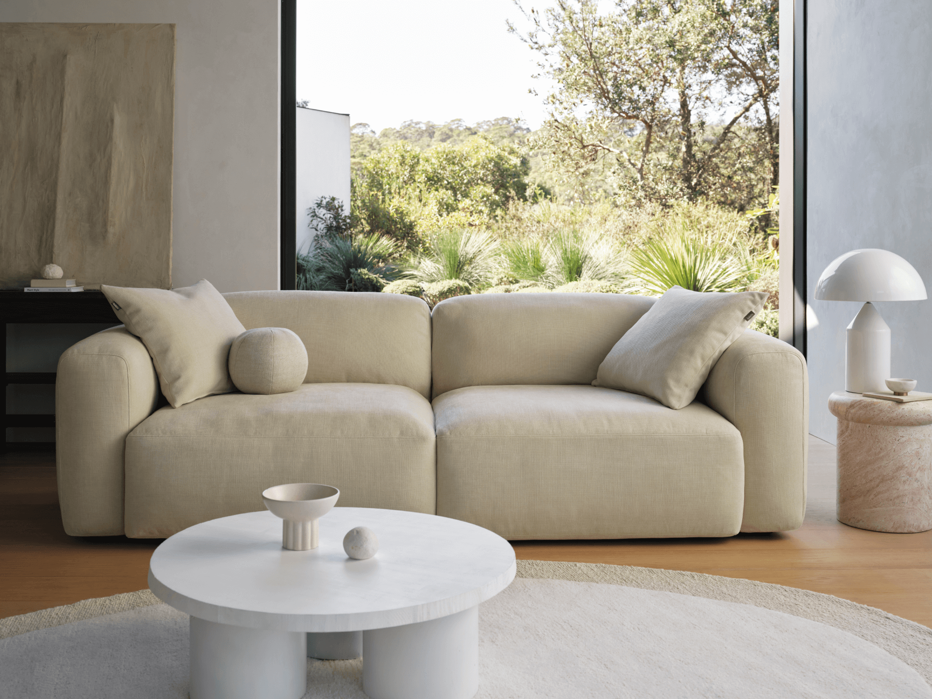 Modern cream fabric sectional sofa with plush cushioning in a sunlit living room
