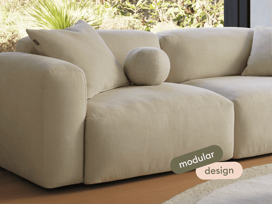 Luxurious beige modular sofa in soft fabric, featuring plush cushions and a minimalist design. Perfectly placed in a serene living room setting.