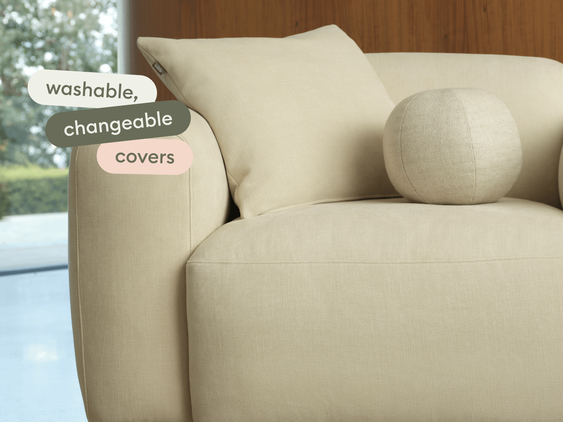 Elegant beige linen armchair with plush, washable and changeable covers. Features sleek lines and a matching cushion in a modern living room.