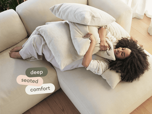 Luxurious cream sectional sofa with plush, deep-seated cushions, set in a sunlit hardwood-floored living space.